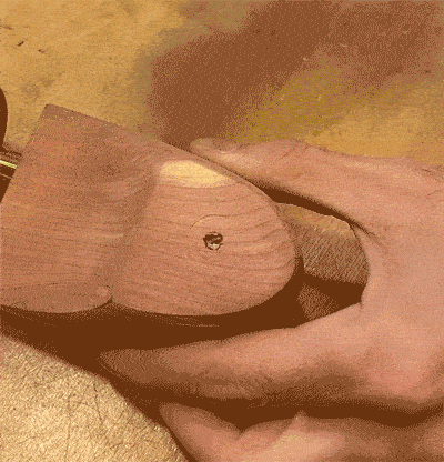 Une main vient enfin re visser la boule d'attache dans le trou rempli par le cure dent pour finir la réparation de l'embauchoir